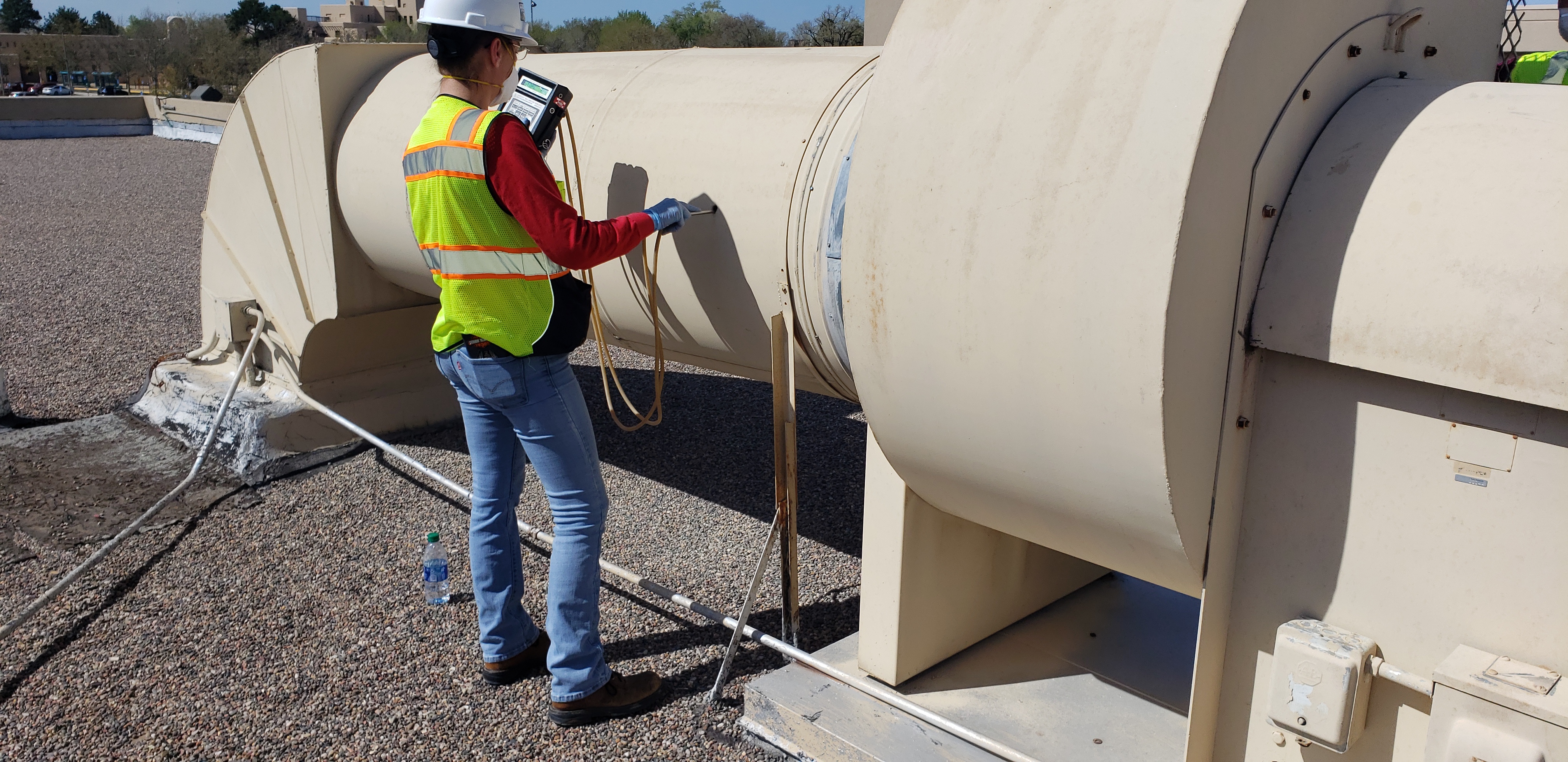 EB&I employee Sarah Moharter performs a duct traverse test to determine  the total airflow of a future isolation area exhaust fan.